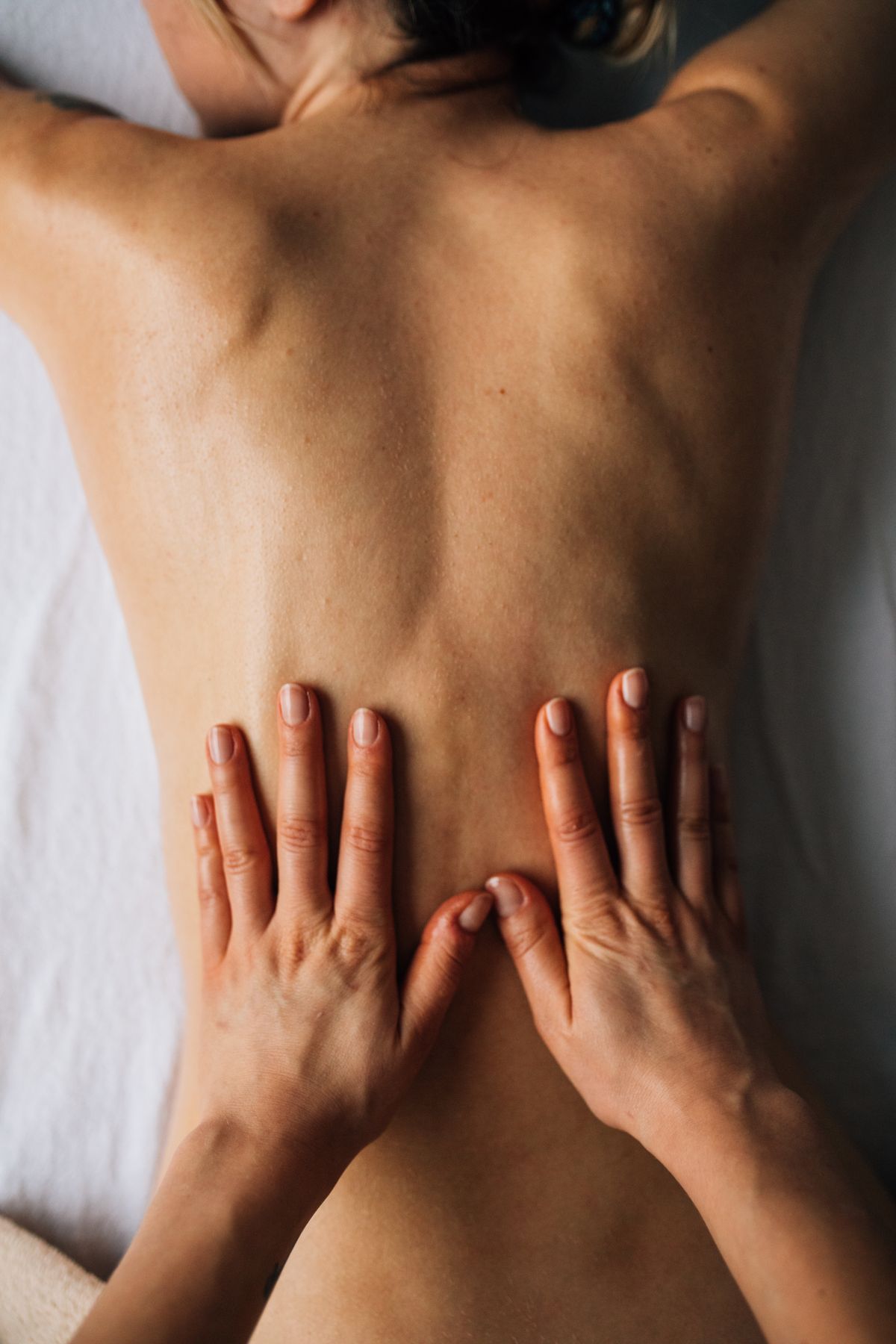 Therapist applying firm pressure along a client's back